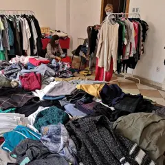Dużo ubrań na stołach i wieszakach. Szukasz, gdzie oddać ubrania w Krakowie? To miejsce może być odpowiedzią.