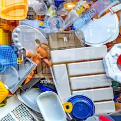 Kolorowy stos plastikowych odpadów, w tym butelki, pojemniki i zabawki. To przykład tego, co to są surowce wtórne.