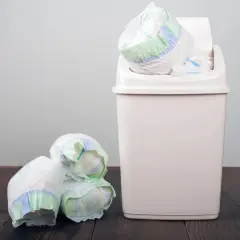 Kupa zużytych pieluch obok kosza, który jest odpowiedzią na pytanie, gdzie wyrzucać pieluchy.