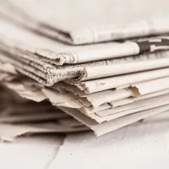 Stos gazet, gotowy do wrzucenia do pojemników na makulaturę.