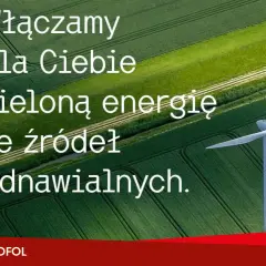 Wiatrak na tle zielonych pól. Napis: "Włączamy dla Ciebie zieloną energię ze źródeł odnawialnych." Co oznacza skrót OZE? To właśnie energia odnawialna.