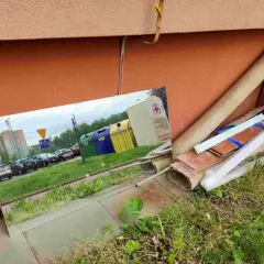Duże lustro odbija śmietniki i parking. Zastanawiasz się, gdzie wyrzucić szyby okienne? Sprawdź lokalne punkty zbiórki odpadów.