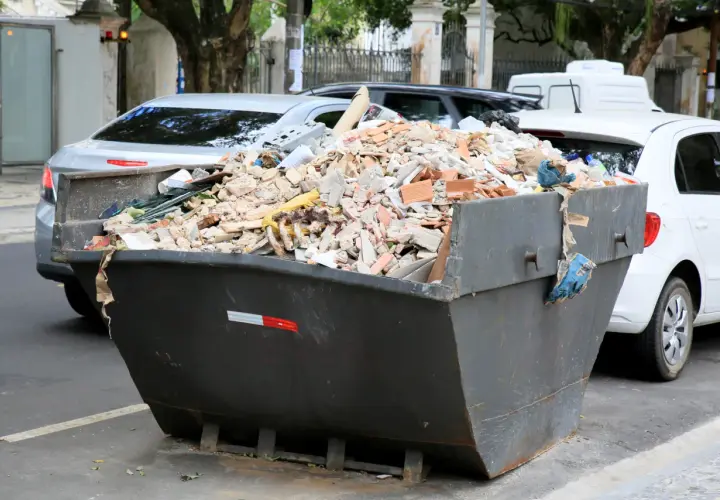 Kontener pełen gruzu budowlanego, cegieł i resztek materiałów. Zastanawiasz się, gdzie wywieźć gruz? Ten widok sugeruje, że problem jest aktualny.