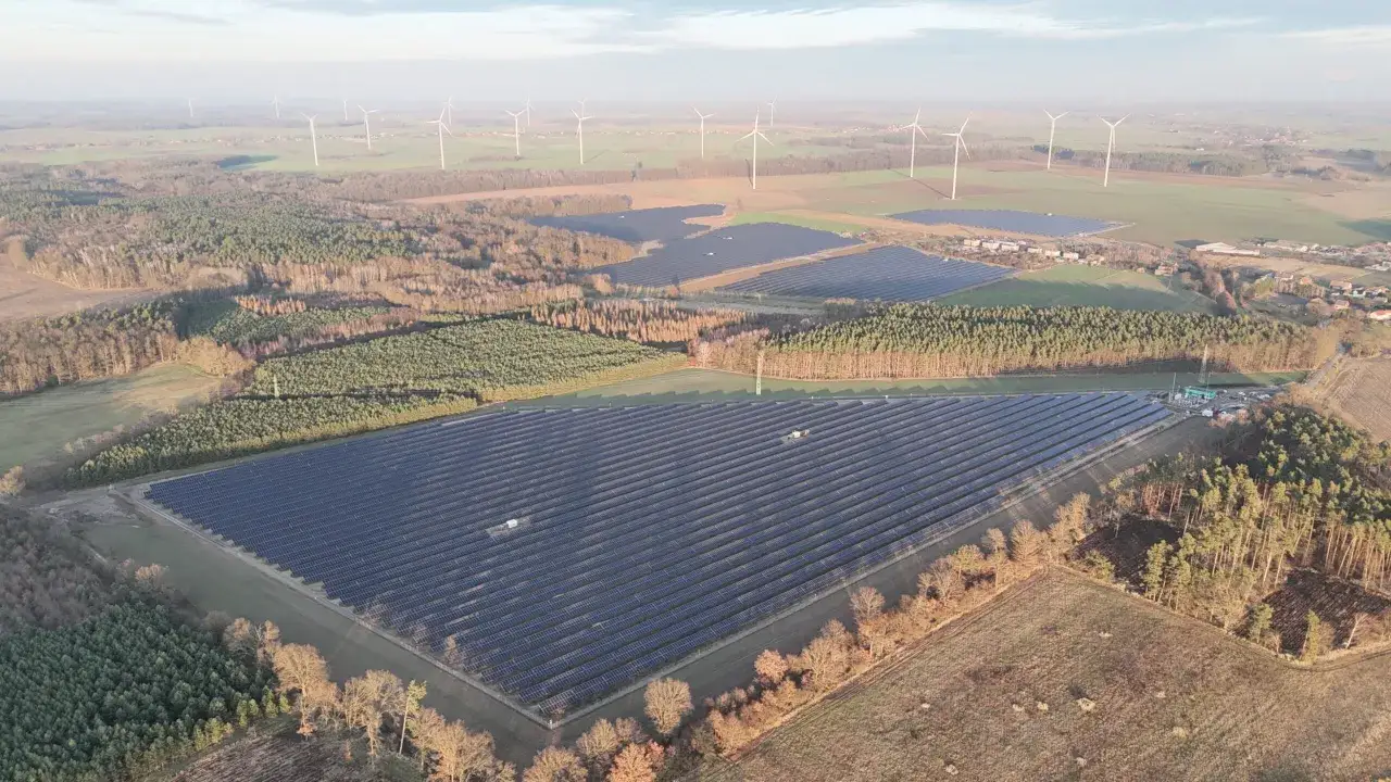 Rozległe farmy fotowoltaiczne i wiatraki świadczą o rozwoju odnawialnych źródeł energii w Polsce.
