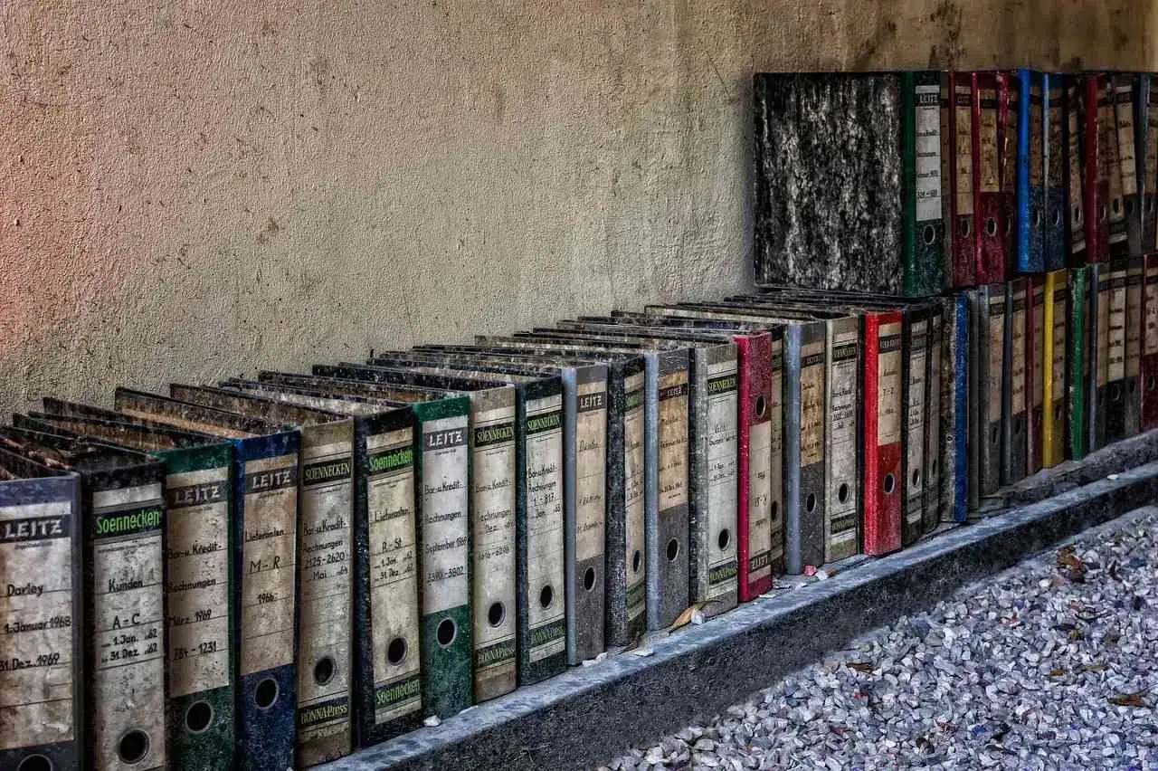 Stare, zakurzone segregatory Leitz stoją w rzędzie. Zastanawiasz się, gdzie wyrzucić segregator? Te archiwa czekają na recykling.